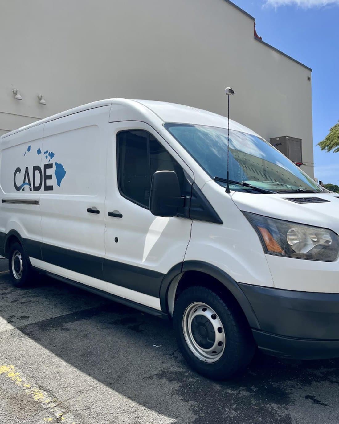 Freshly washed CADE work van, its logo clean and bright in the sun